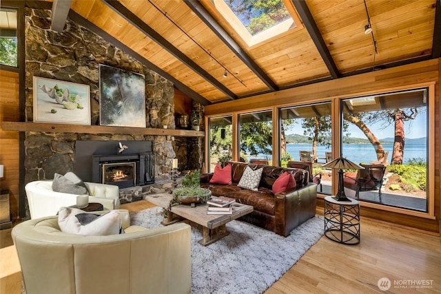 512 Broken Point Rd, Shaw Island, WA 98286 - living room featuring wooden ceiling, healthy amount of natural light, wood finished floors, a stone fireplace, and a water view