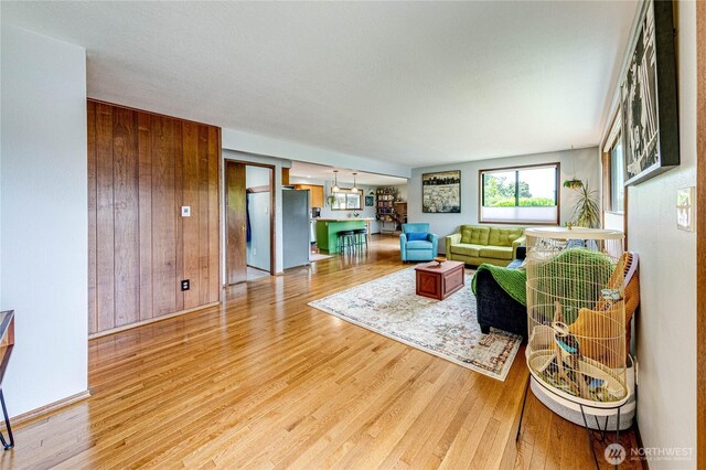 1121 W 12th St, Port Angeles, WA 98363 - living room featuring light wood-style flooring and wood walls