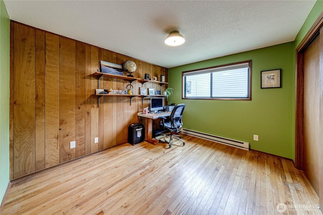 1121 W 12th St, Port Angeles, WA 98363 - office space featuring a baseboard heating unit, light wood-type flooring, wooden walls, and a textured ceiling