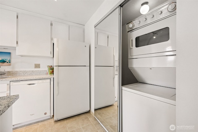 516 S 222nd St Unit 4, Des Moines, WA 98198 - kitchen featuring white appliances, stacked washer and clothes dryer, and white cabinets