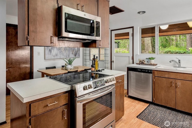 15025 SE 22nd St, Bellevue, WA 98007 - kitchen featuring stainless steel appliances, light countertops, light wood finished floors, and a kitchen island