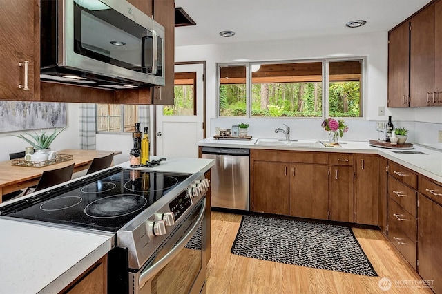 15025 SE 22nd St, Bellevue, WA 98007 - kitchen featuring appliances with stainless steel finishes, light countertops, light wood-type flooring, and healthy amount of natural light