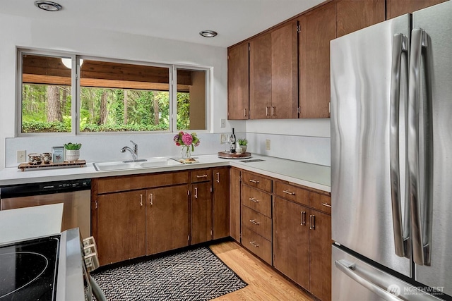 15025 SE 22nd St, Bellevue, WA 98007 - kitchen featuring stainless steel appliances, light countertops, and light wood-style floors