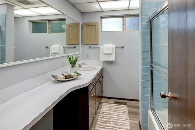 15025 SE 22nd St, Bellevue, WA 98007 - full bath with vanity, wood finished floors, combined bath / shower with glass door, and a paneled ceiling