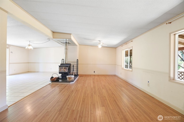 15932 427th Ave SE, Gold Bar, WA 98251 - unfurnished living room featuring a wood stove, wood finished floors, ceiling fan, and plenty of natural light