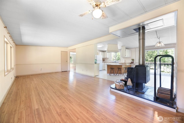 15932 427th Ave SE, Gold Bar, WA 98251 - living area with a wood stove, light wood-style flooring, and a ceiling fan