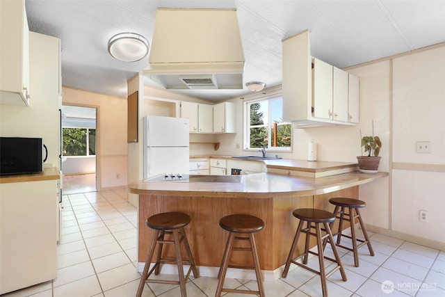 15932 427th Ave SE, Gold Bar, WA 98251 - kitchen with black appliances, a peninsula, light tile patterned flooring, and a breakfast bar area