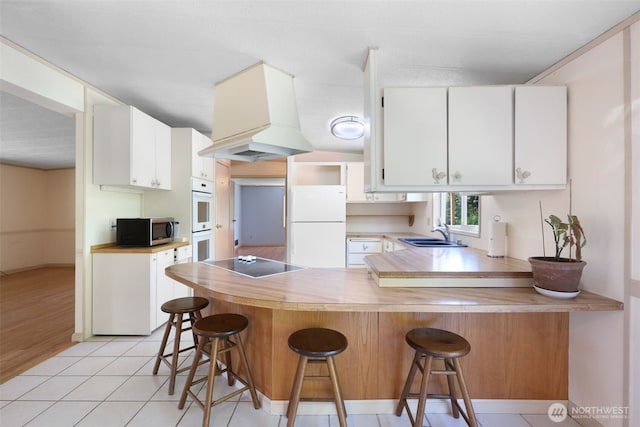 15932 427th Ave SE, Gold Bar, WA 98251 - kitchen with white appliances, a peninsula, white cabinets, and a kitchen bar