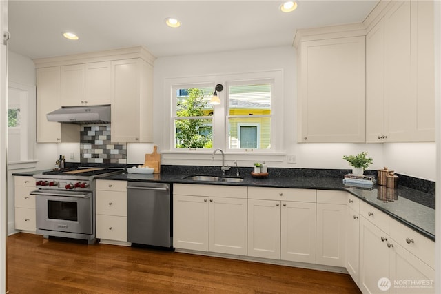 1515 2nd Ave W, Seattle, WA 98119 - kitchen featuring appliances with stainless steel finishes, under cabinet range hood, dark wood-style flooring, white cabinets, and recessed lighting