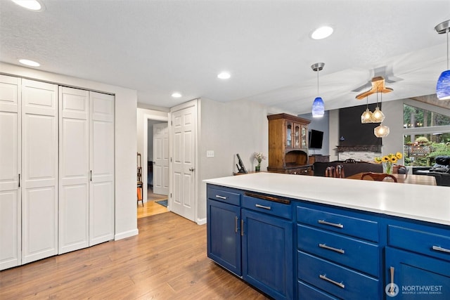 19833 95th Ave NE, Bothell, WA 98011 - kitchen featuring blue cabinetry, light wood-type flooring, light countertops, recessed lighting, and decorative light fixtures