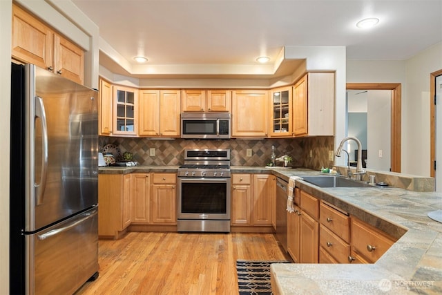 3120 Tanglewood Ln, Bellingham, WA 98226 - kitchen featuring appliances with stainless steel finishes, light wood-style floors, backsplash, glass insert cabinets, and light brown cabinetry
