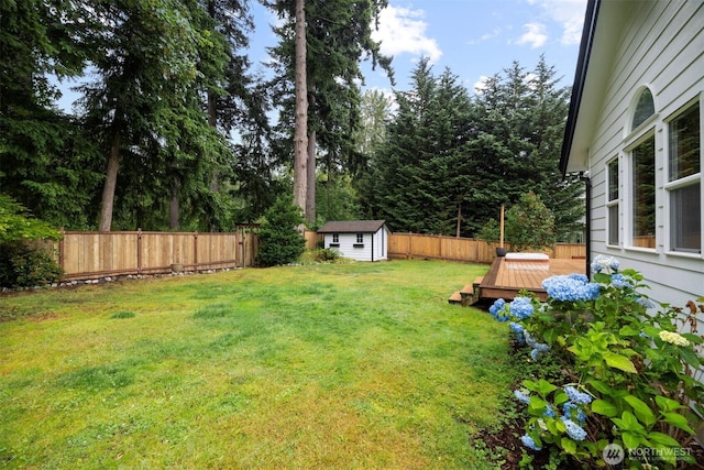 3120 Tanglewood Ln, Bellingham, WA 98226 - fenced backyard featuring a storage unit, a wooden deck, and view of wooded area