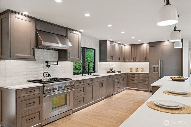 23406 Humber Ln, Edmonds, WA 98020 - kitchen with high end stove, wall chimney exhaust hood, light wood-type flooring, light countertops, and recessed lighting