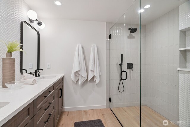 23406 Humber Ln, Edmonds, WA 98020 - bathroom with wood finished floors, tiled shower, double vanity, and recessed lighting