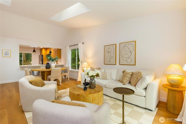 14703 121st Ct NE, Kirkland, WA 98034 - living room featuring a skylight, plenty of natural light, light wood-style floors, and vaulted ceiling