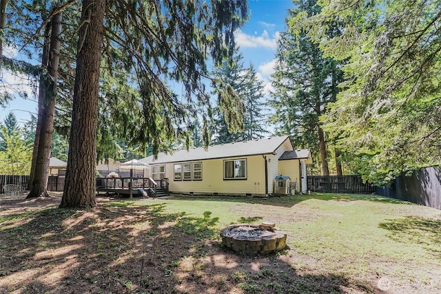 15922 Lindsay Rd SE, Yelm, WA 98597 - back of property featuring a fenced backyard, a deck, a fire pit, and crawl space