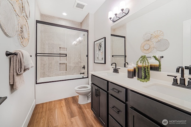 5738 S Zabo Rd, Spokane, WA 99224 - full bathroom with double vanity, wood finished floors, enclosed tub / shower combo, and recessed lighting