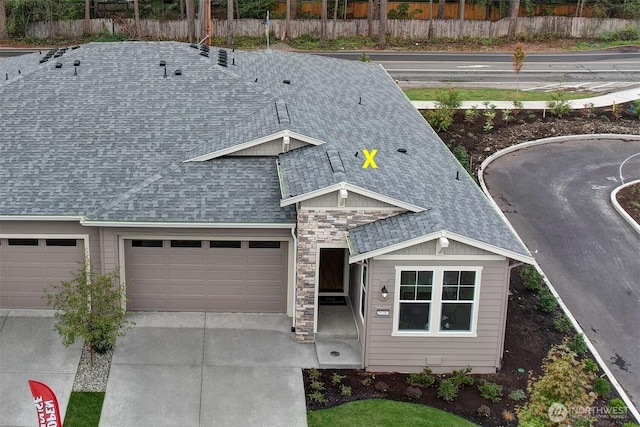 29207 217th Pl SE Unit 1, Black Diamond, WA 98010 - view of front facade featuring roof with shingles, concrete driveway, an attached garage, and stone siding