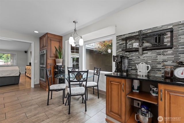 4709 144th St E, Tacoma, WA 98446 - bar area with backsplash, double oven, light wood-style flooring, decorative light fixtures, and a chandelier