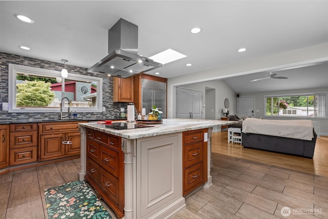 4709 144th St E, Tacoma, WA 98446 - kitchen with island exhaust hood, built in refrigerator, open floor plan, a skylight, and wood tiled floors