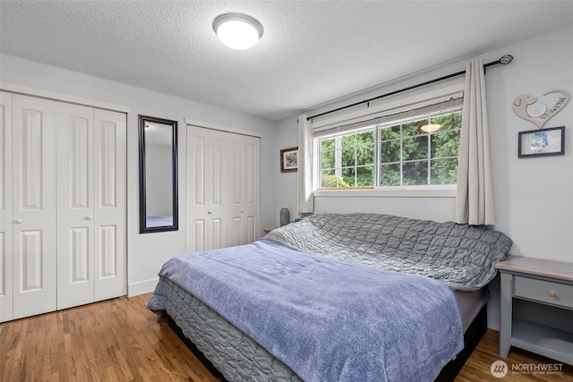 4709 144th St E, Tacoma, WA 98446 - bedroom featuring two closets, wood finished floors, and a textured ceiling