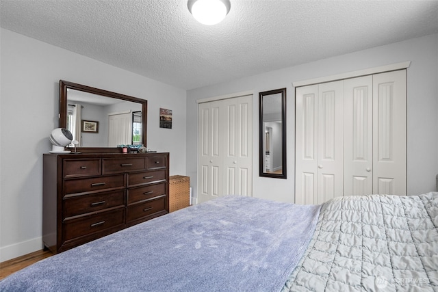 4709 144th St E, Tacoma, WA 98446 - bedroom featuring two closets, wood finished floors, and a textured ceiling