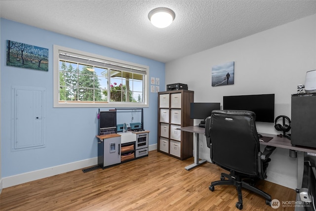 4709 144th St E, Tacoma, WA 98446 - office area featuring electric panel, light wood-type flooring, and a textured ceiling
