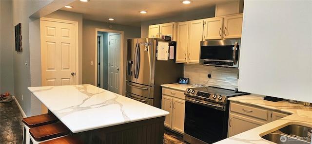 31505 46th Ave S, Auburn, WA 98001 - kitchen featuring appliances with stainless steel finishes, tasteful backsplash, recessed lighting, light stone counters, and a kitchen island