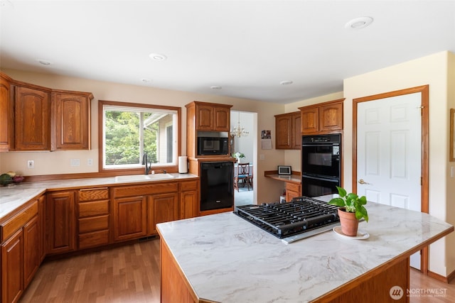 3517 Frogs Leap Ln NE, Olympia, WA 98506 - kitchen featuring black appliances, brown cabinets, light wood-style flooring, a center island, and recessed lighting