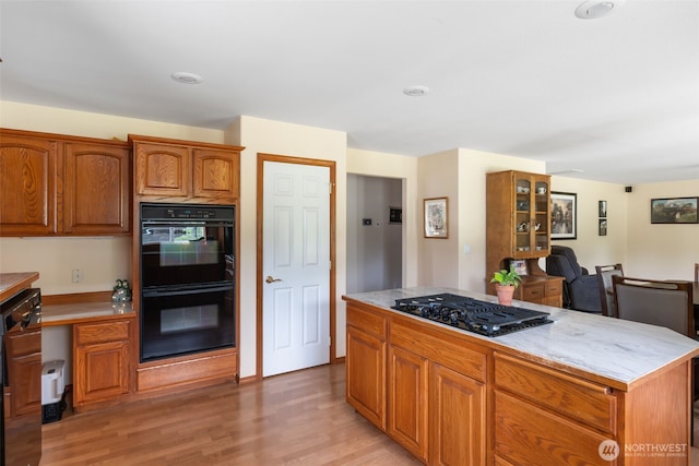 3517 Frogs Leap Ln NE, Olympia, WA 98506 - kitchen featuring gas cooktop, light countertops, light wood-style flooring, and brown cabinets