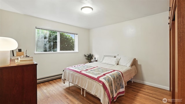 1001 1st Ave N, Seattle, WA 98109 - bedroom featuring a baseboard radiator and wood finished floors