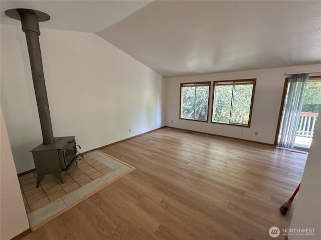 1430 Welling Rd, Bellingham, WA 98226 - unfurnished living room featuring a wood stove, wood finished floors, and lofted ceiling