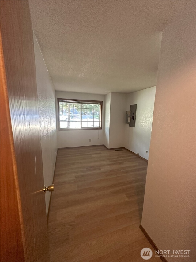1430 Welling Rd, Bellingham, WA 98226 - empty room featuring electric panel, a textured ceiling, wood finished floors, and a textured wall