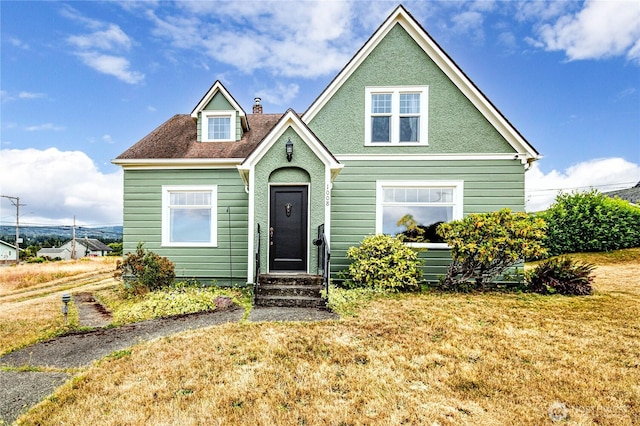 1008 W 5th St N, Port Angeles, WA 98363 - view of front of house featuring a front lawn, a chimney, and stucco siding