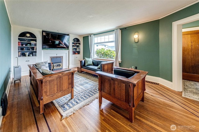 1008 W 5th St N, Port Angeles, WA 98363 - living area with built in features, a fireplace, and wood finished floors