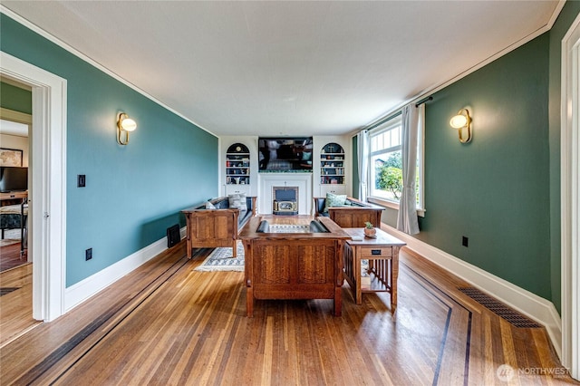 1008 W 5th St N, Port Angeles, WA 98363 - living area featuring a fireplace, built in features, crown molding, and wood finished floors