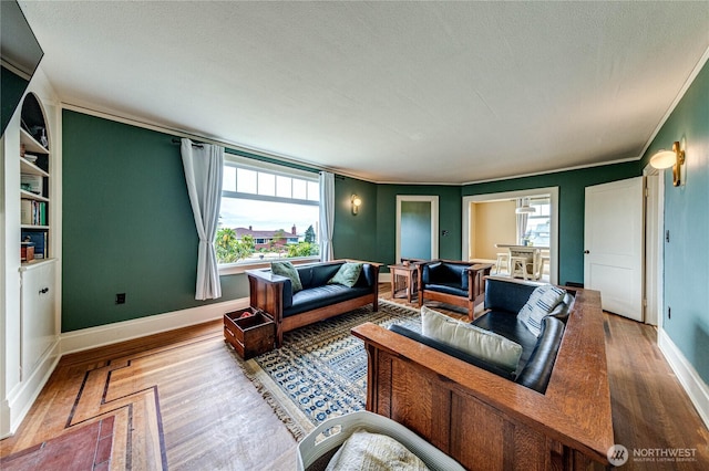 1008 W 5th St N, Port Angeles, WA 98363 - living room featuring wood finished floors, crown molding, a textured ceiling, and built in features