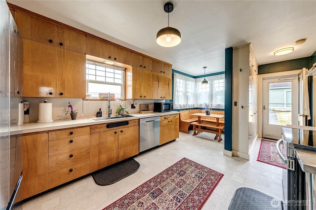 1008 W 5th St N, Port Angeles, WA 98363 - kitchen featuring stainless steel appliances, light countertops, hanging light fixtures, light floors, and brown cabinets