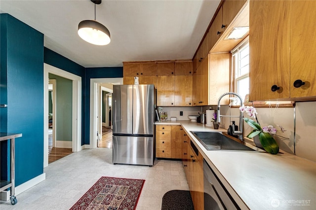 1008 W 5th St N, Port Angeles, WA 98363 - kitchen with appliances with stainless steel finishes, light countertops, brown cabinets, hanging light fixtures, and light flooring