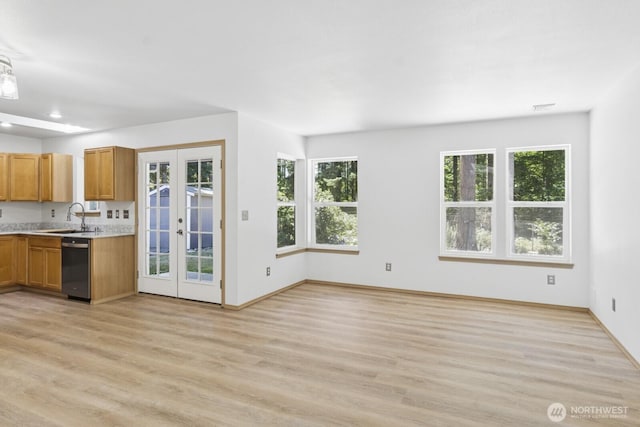 17701 Vine Ln SE, Yelm, WA 98597 - kitchen with stainless steel dishwasher, light countertops, light wood-type flooring, brown cabinets, and french doors