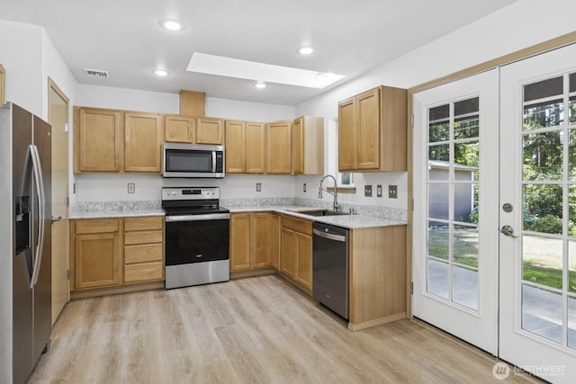 17701 Vine Ln SE, Yelm, WA 98597 - kitchen with appliances with stainless steel finishes, a skylight, light wood-style floors, plenty of natural light, and recessed lighting