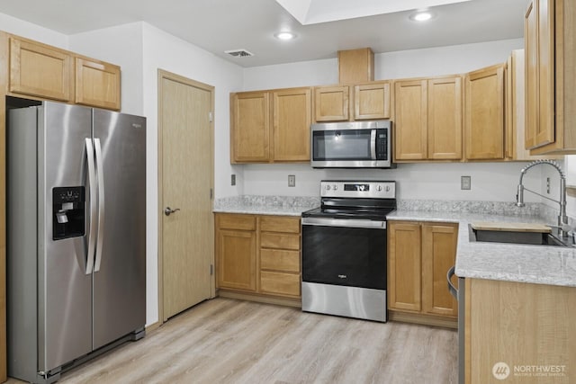 17701 Vine Ln SE, Yelm, WA 98597 - kitchen featuring appliances with stainless steel finishes, light wood-type flooring, light stone countertops, and recessed lighting