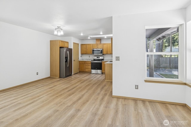 17701 Vine Ln SE, Yelm, WA 98597 - kitchen featuring stainless steel appliances, light wood-style flooring, light countertops, recessed lighting, and brown cabinetry
