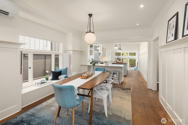 5526 34th Ave NE, Seattle, WA 98105 - dining space featuring wood finished floors, a wall mounted AC, ornamental molding, and a decorative wall
