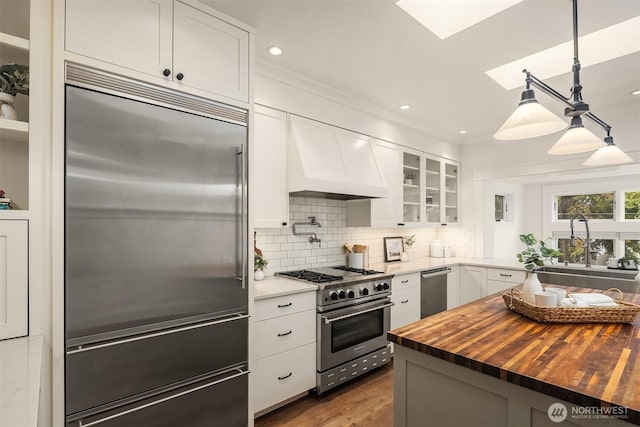 5526 34th Ave NE, Seattle, WA 98105 - kitchen with high quality appliances, wood counters, a skylight, glass insert cabinets, and white cabinets