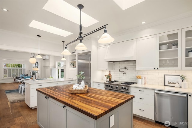 5526 34th Ave NE, Seattle, WA 98105 - kitchen with a skylight, appliances with stainless steel finishes, wood counters, a kitchen island, and dark wood-style flooring