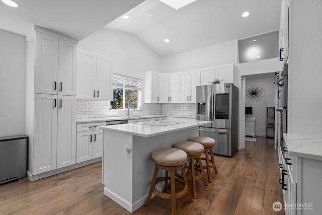 37509 21st Ave S, Federal Way, WA 98003 - kitchen with stainless steel fridge, light wood finished floors, tasteful backsplash, white cabinets, and vaulted ceiling