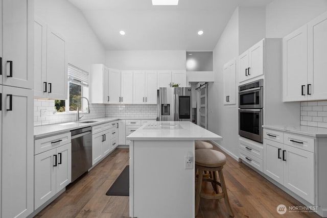 37509 21st Ave S, Federal Way, WA 98003 - kitchen featuring stainless steel appliances, a breakfast bar, a kitchen island, white cabinets, and tasteful backsplash