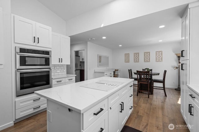 37509 21st Ave S, Federal Way, WA 98003 - kitchen with stovetop with downdraft, double oven, a center island, dark wood-style floors, and light stone counters