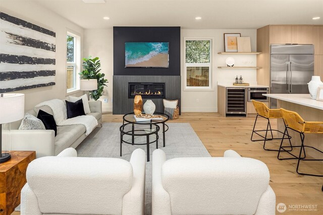 819 18th Ave W, Kirkland, WA 98033 - living room featuring wine cooler, light wood-type flooring, recessed lighting, a glass covered fireplace, and bar area